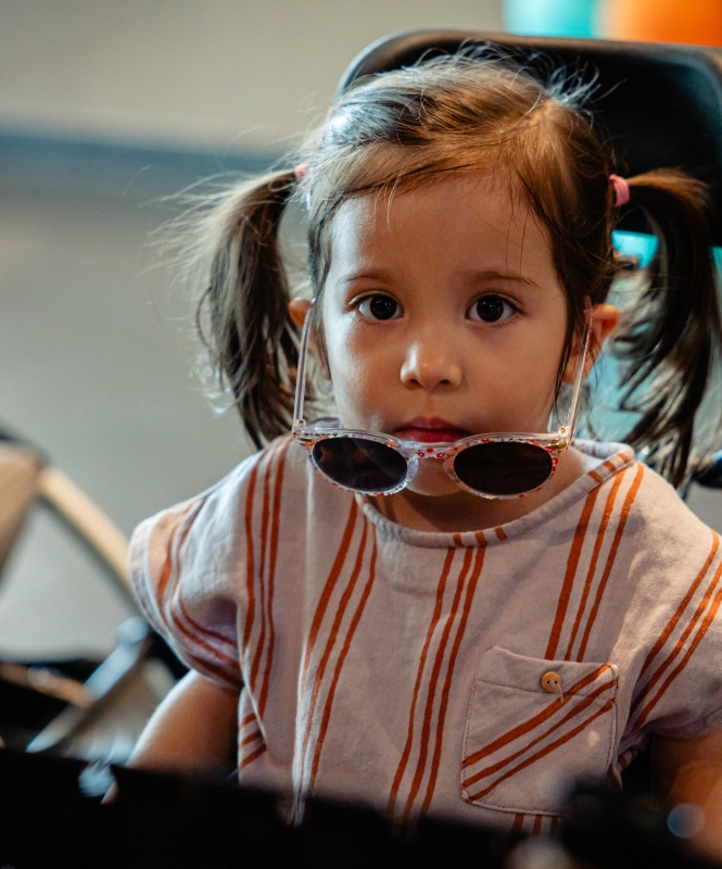 Spierziekten bij kinderen zijn enorm ingrijpend. Meisje met een spierziekte kijkt in camera.