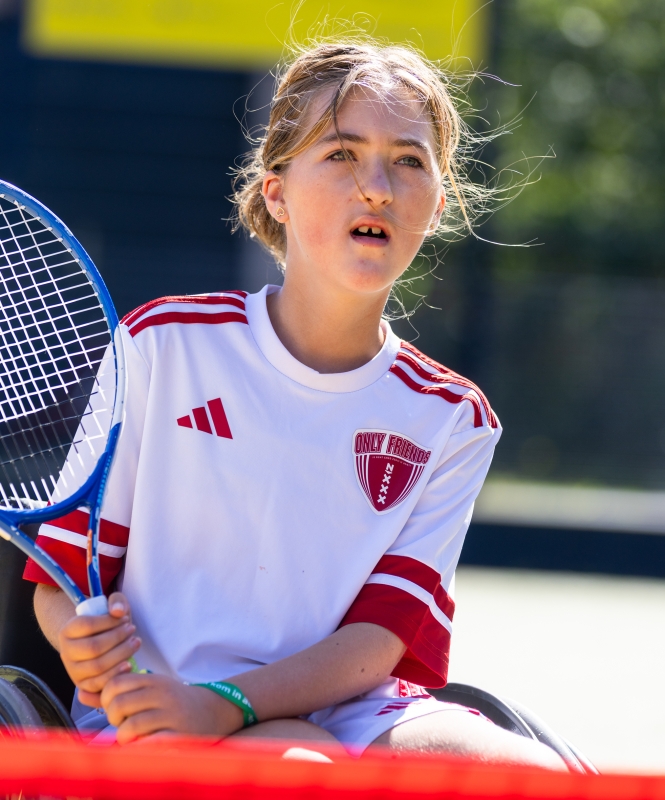 Sport en Bewegen voor Kinderen met een spierziekte. KInd-ambassadeur in een rolstoel aan het tennissen.